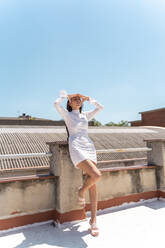 Frau auf dem Dach in modischem weißen Kleid - AFVF03432