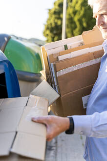 Älterer Mann recycelt Pappe in der Papiersammlung - AFVF03452