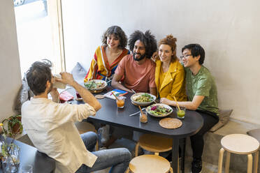 Gruppe von Freunden beim Mittagessen in einem Restaurant, die ein Foto machen - AFVF03499