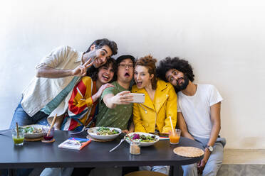 Gruppe von Freunden beim Mittagessen in einem Restaurant, die ein Selfie machen - AFVF03500