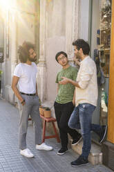 Drei junge Männer unterhalten sich in der Stadt - AFVF03531
