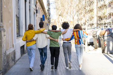 Rear view of group of friends walking arm in arm in the city - AFVF03533