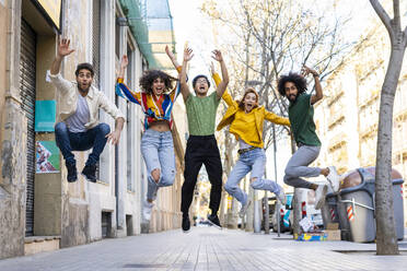 Glückliche Gruppe von Freunden, die in der Stadt Spaß haben und in der Luft springen - AFVF03547
