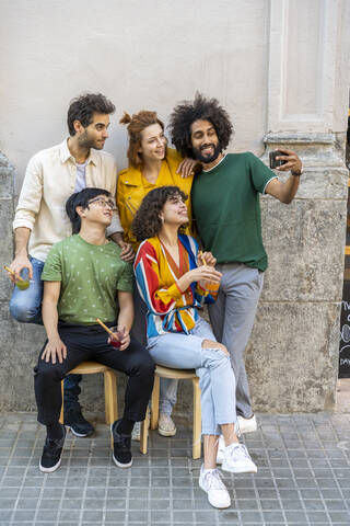 Mann macht ein Selfie mit Freunden in der Stadt, lizenzfreies Stockfoto