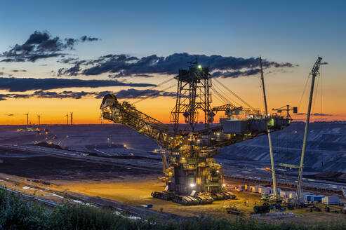 High angle view of bucket-wheel excavator at mine against sky during sunset - FR00856