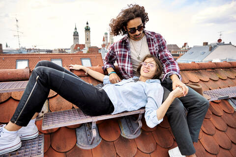 Junges Paar entspannt sich auf einer Dachterrasse, lizenzfreies Stockfoto