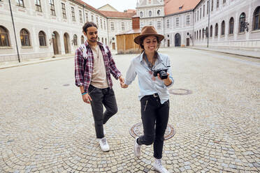 Junges Touristenpaar bei einem Spaziergang im Innenhof der Münchner Residenz, München, Deutschland - SUF00586