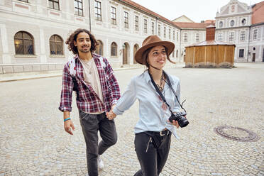 Junges Touristenpaar bei einem Spaziergang im Innenhof der Münchner Residenz, München, Deutschland - SUF00587