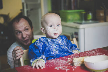 Vater mit seinem kleinen Sohn nach einer unordentlichen Mahlzeit - IHF00150