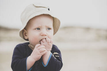 Baby boy eating sand on the beach - IHF00151