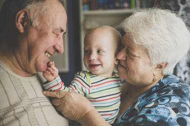 Happy grandparents holding their baby grandson - IHF00160