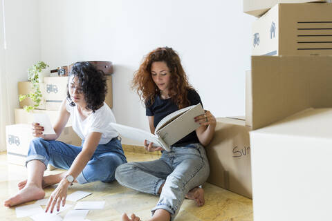 Two friends moving into new home stock photo