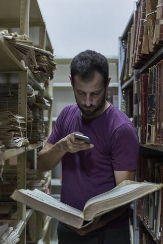 Mann fotografiert ein altes Buch in der Nationalbibliothek, Maputo, Mocambique, lizenzfreies Stockfoto