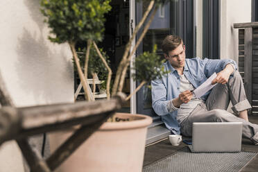 Man sitting on terrace, using laptop - UUF18036