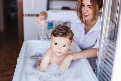 Mother bathing her little son stock photo