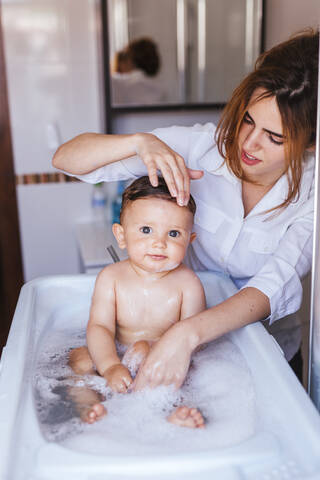Mutter badet ihren kleinen Sohn, lizenzfreies Stockfoto