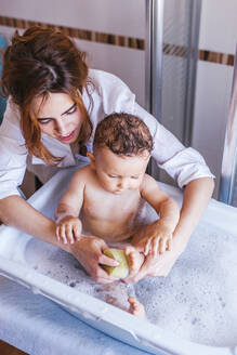 Mutter badet ihren kleinen Sohn - LJF00274