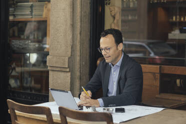 Geschäftsmann bei der Arbeit in einem Kaffeehaus - ALBF00884