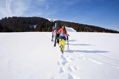 Fünf jugendliche Skifahrerinnen mit Skiern in verschneiter Landschaft, Rückansicht, Tirol, Steiermark, Österreich - CUF51671