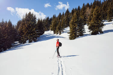 Älterer männlicher Schneeschuhwanderer, der von einer verschneiten Berglandschaft aufblickt, Steiermark, Tirol, Österreich - CUF51719