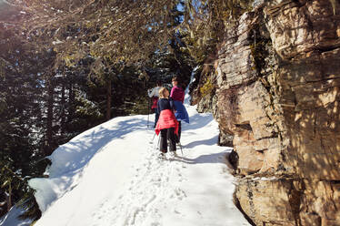 Teenager-Mädchen und Schwestern beim Schneeschuhwandern an einem verschneiten Berghang, Steiermark, Tirol, Österreich - CUF51721