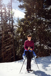 Jugendliches Mädchen beim Schneeschuhwandern im verschneiten Bergwald, Porträt, Steiermark, Tirol, Österreich - CUF51722