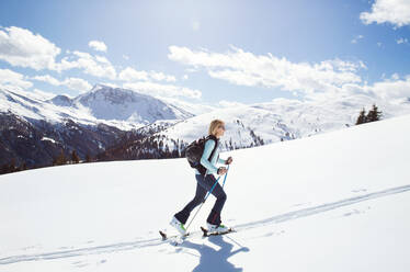 Mature woman snowshoeing up snow covered mountainside, Styria, Tyrol, Austria - CUF51723