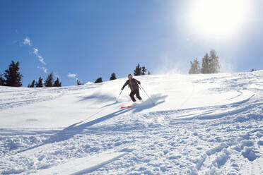 Älterer Mann beim Skifahren auf einem sonnenbeschienenen, schneebedeckten Berg, Steiermark, Tirol, Österreich - CUF51731