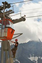 Wartungsarbeiter klettert auf Seilbahn, Saas-Fee, Wallis, Schweiz - CUF51766