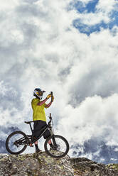 Mountain biker taking photo, Saas-Fee, Valais, Switzerland - CUF51770