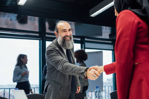 Geschäftspartner schütteln sich bei einem Treffen im Büro die Hände, lizenzfreies Stockfoto