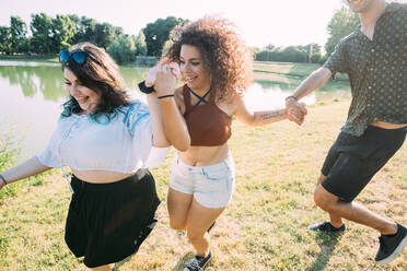 Group of friends having fun by lake - CUF51867