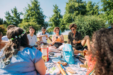 Eine Gruppe von Freunden entspannt sich bei einem Picknick im Park - CUF51868