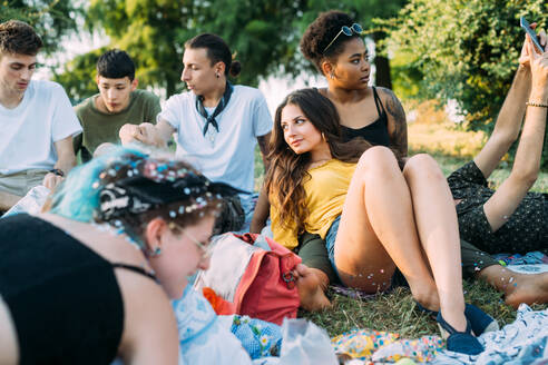 Eine Gruppe von Freunden entspannt sich bei einem Picknick im Park - CUF51897