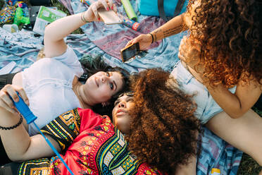 Eine Gruppe von Freunden entspannt sich bei einem Picknick im Park - CUF51899