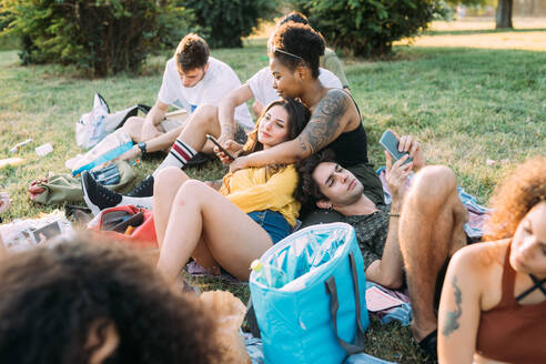 Eine Gruppe von Freunden entspannt sich bei einem Picknick im Park - CUF51905
