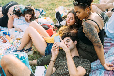 Group of friends relaxing at picnic in park - CUF51906