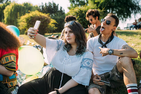 Gruppe von Freunden entspannen, nehmen Selfie beim Picknick im Park - CUF51923