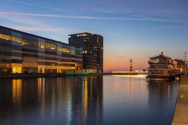 Illuminated buildings by river against sky in Malmo, Sweden - TAMF01671