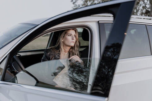 Blonde Frau sitzt in weißem Auto - ERRF01524