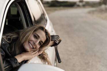 Blond woman in white car looking out of the window - ERRF01535