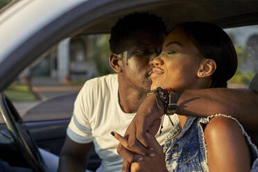 Junges Paar im Auto sitzend, küssend - VEGF00362