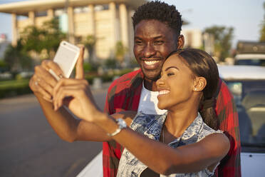 Junges Paar macht Selfies mit dem Samrtphone, Mabuto, Mosambik - VEGF00363