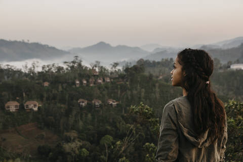 Rückansicht einer Frau, die bei Sonnenuntergang die Berge gegen den Himmel betrachtet, Sri Lanka, lizenzfreies Stockfoto