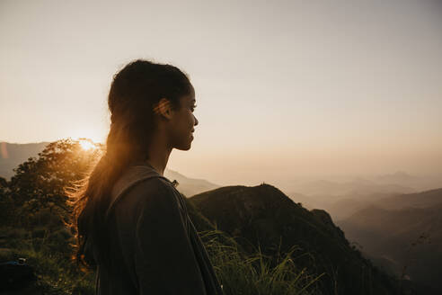 Wanderin beim Wandern auf einem Berg in Sri Lanka gegen den Himmel bei Sonnenuntergang, Sri Lanka - LHPF00727