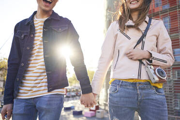 Lachendes Paar, das am Abend Hand in Hand spazieren geht, Barcelona, Spanien - DVGF00043