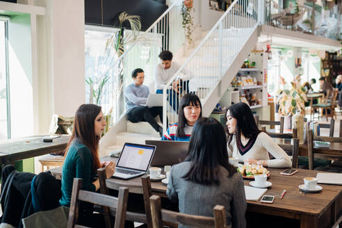 Junge Geschäftsfrauen, die per Fernzugriff arbeiten, treffen sich am Kaffeetisch - CUF52066