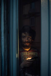 Bearded young man in deep thought by window - CUF52138