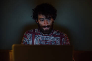 Bearded young man using laptop at home - CUF52149