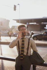 Businessman using smartphone on pavement, Milano, Lombardia, Italy - CUF52162